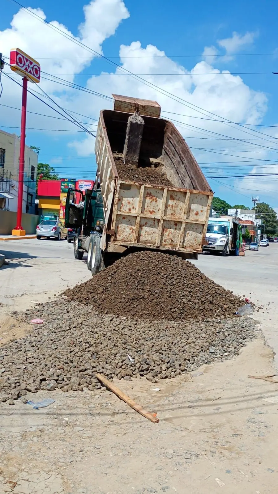 Camión de volteo descargando grava en la calle