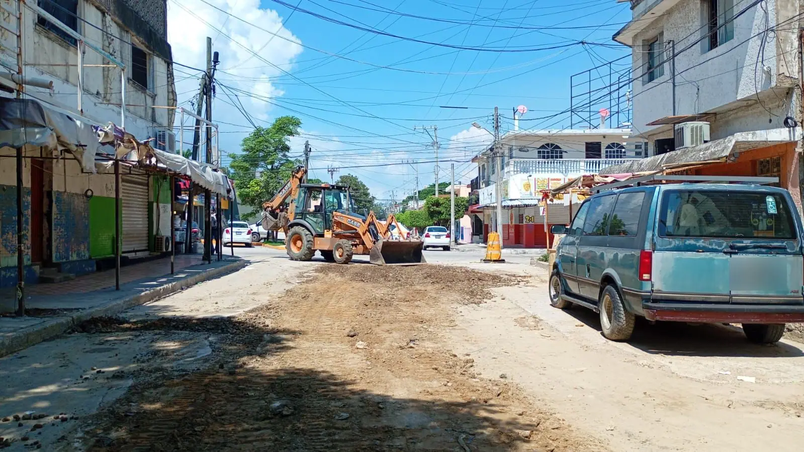 Retroexcavadora nivelando el material de una calle en reparación
